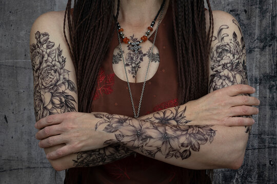 50 year old woman's arms and body tattooed with braids

