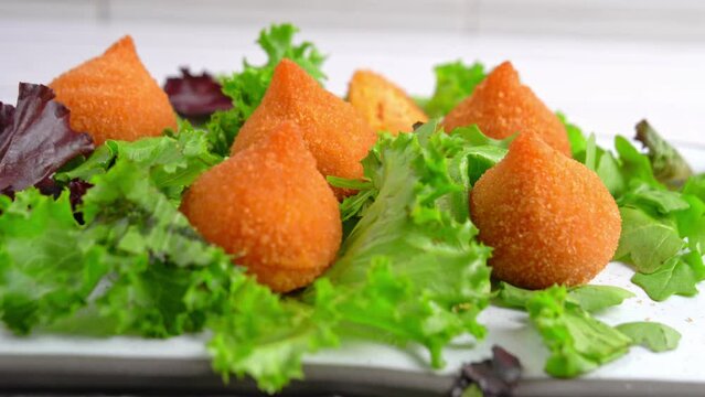 Traditional fried coxinha de frango - croquette of chicken on the white table, Brazilian snack.