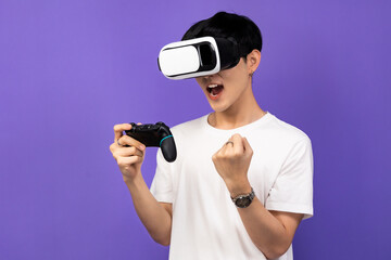 Young Asian man wearing VR headset enjoy playing video game  on futuristic purple cyberpunk.Man using VR headset while experiencing the virtual reality over an isolated background. © anon