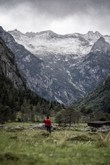 Fototapeta na wymiar Hiker facing the Pizzo Ligoncio from the area of Val di Mello, located in Masino Valley, Northern Italy 