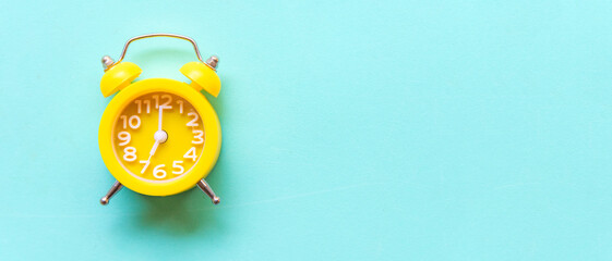 Alarm yellow vintage alarm clock falling on the floor with blue color background, copy space for...