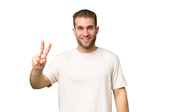 Young handsome caucasian man isolated on green chroma background smiling and showing victory sign