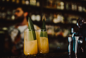two orange alcohol cocktail in glass at the bar counter.