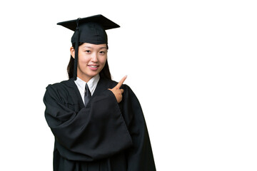 Young university graduate Asian woman over isolated background pointing to the side to present a...