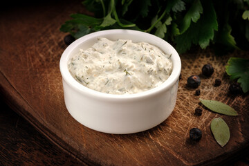Zadziki sauce in a gravy boat is a Greek dish based on yogurt, cucumber, garlic and herbs on wood