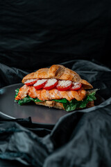 grilled salmon steak with tomato in croissant