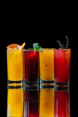 four lemonades of different flavors on a black background