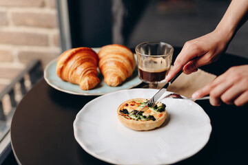 Quiche with salmon and broccoli in a shortcrust pastry, with a creamy sauce. On a beautiful white plate.