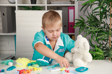 A boy with Down syndrome plays with toys on the table, early development and education of children,...