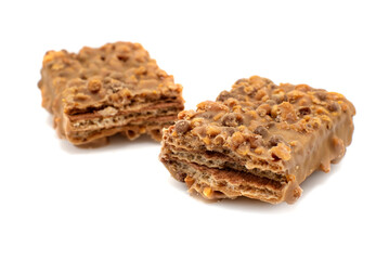 Waffle chocolate bar with nuts broken into two parts close up, isolated on white background
