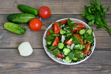 garden vegetable salad with tomato, cucumber, onion and parsley isolated, close-up
