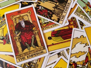 Picture of The Emperor tarot card from the original Rider Waite tarot deck with mixed tarot cards in the background