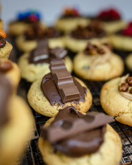 Un cookie avec du chocolat et un morceau de kinder dans la vitrine d'une pâtisserie