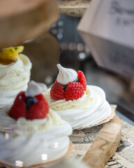 Une pâtisserie à la crème et aux framboises avec une feuille d'or dans une vitrine