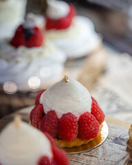 Une pâtisserie à la crème et aux framboises avec une feuille d'or dans une vitrine