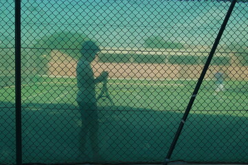 Blurred picture with a boy and a racket on the tennis court.
