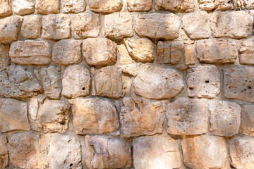 Texture of wall surface made of unevenly cut Jerusalem stones.