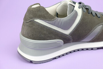 Sneakers for everyday use. Sneaker heel with suede and fabric parts on a pale lilac background....