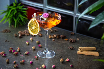 an original cocktail decorated with ice with a frozen flower. Bar pink cocktail in a martini glass.
