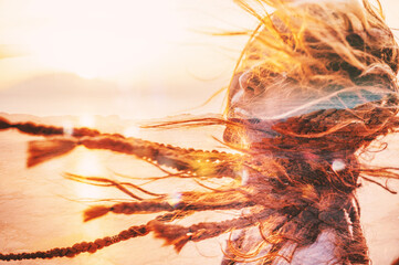Woman with hair blowing in the wind during sunset