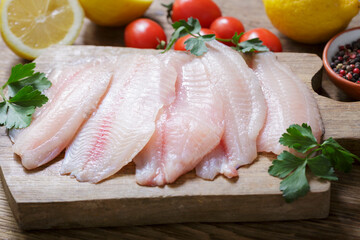 fresh fish fillet of tilapia with ingredients for cooking
