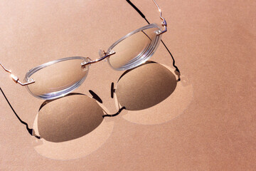 Eye Glasses with strong shadows on brown background