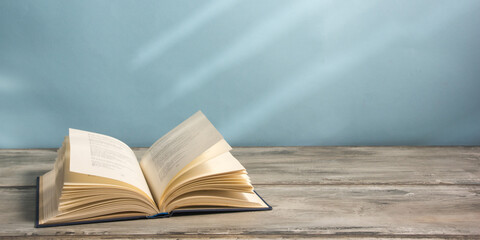 Vintage old hardback books, diary, fanned pages on wooden desk table and grunge background Daylight. Books stacking. Back to school. Copy Space. Education background.