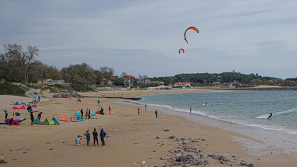 Santander, Spain - 31 Oct, 2022: Kite surfers and bathers on the Playa de los Peligros beach,...