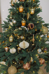 Christmas Tree decoration in gold colors. Winter holidays background. Modern home interior.