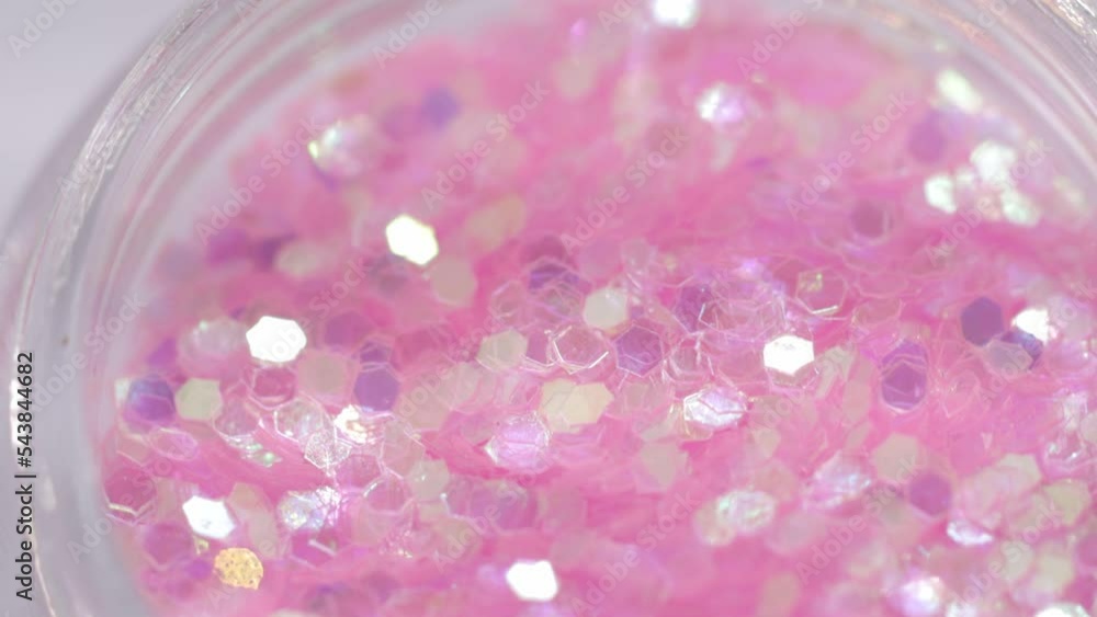 Poster pink sequins in a jar rotate in a circle