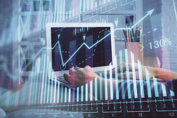 Double exposure of woman hands typing on computer and forex chart hologram drawing. Stock market...