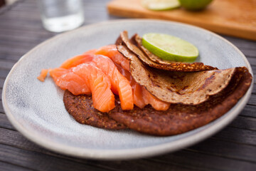 salted salmon fillet with buckwheat pancakes and lime