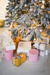 the room is decorated with New Year's decor, a Christmas tree and garlands with balls and gifts
