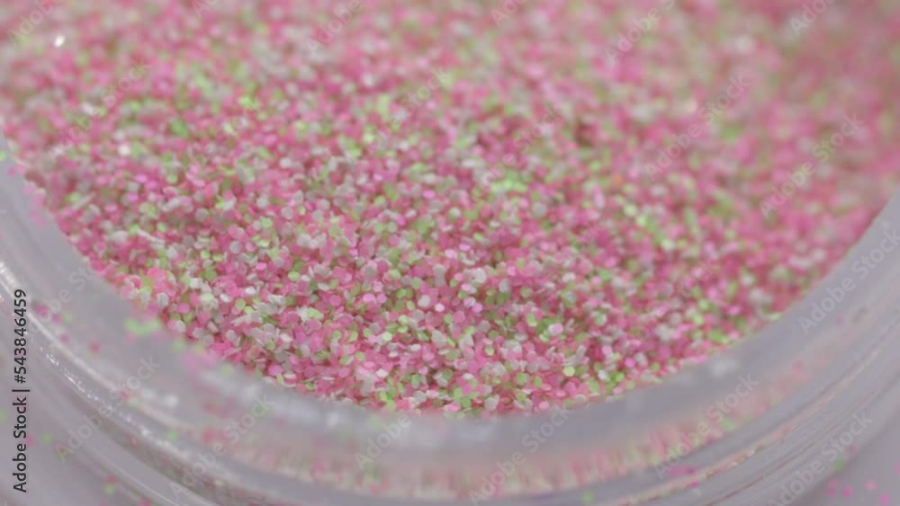 Poster pink sequins in a jar rotate in a circle