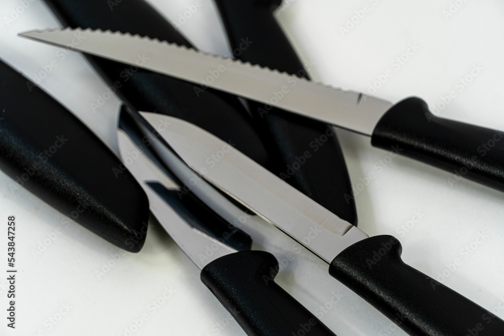 Poster top view of multiple sharpened knives with black handles and metallic blade