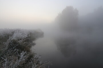 Fototapeta na wymiar River bank in the morning in the fall with fog. 