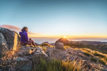 Tragetasche Sitzende Frau, die den Sonnenaufgang über der wunderschönen Berglandschaft von Pico do Ariero beobachtet. Pico do Arieiro, Insel Madeira, Portugal, Europa. © Michael