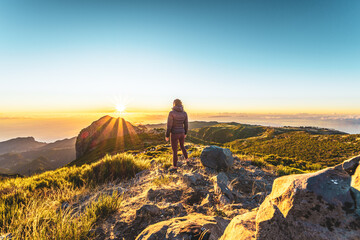 Woman enjoying beautiful mountain landscape of Pico do Ariero during sunrise. Pico do Arieiro,...