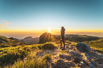 Woman enjoying beautiful mountain landscape of Pico do Ariero during sunrise. Pico do Arieiro,...