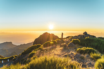 Woman enjoying beautiful mountain landscape of Pico do Ariero during sunrise. Pico do Arieiro,...