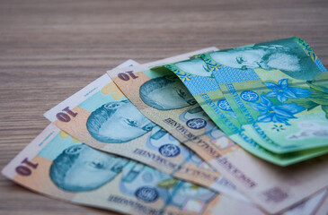 Romanian banknote money on a wooden table.