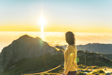 Woman enjoying beautiful mountain landscape of Pico do Ariero during sunrise. Pico do Arieiro,...