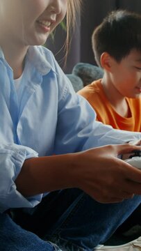 Mom and son have fun playing video games at home