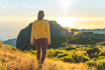 Woman enjoying beautiful mountain landscape of Pico do Ariero during sunrise. Pico do Arieiro,...
