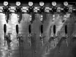 Row of beer tap lines for cold draft beer in pub and restaurant. Craft beer dispenser, beverage...