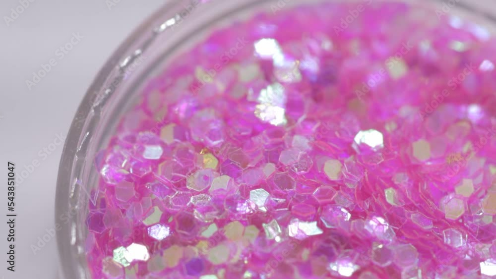 Poster pink sequins in a jar rotate in a circle