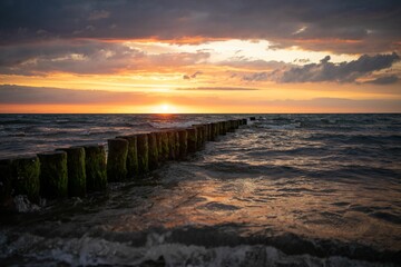 Beautiful shot of wooden breakwater in Baltic seascape during sunset