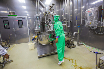 Male operation green protective clothes process in a food factory. the processing production line...