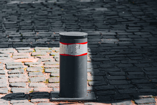 Retractable pole that forbids the car access in a certain area on a paved sidewalk