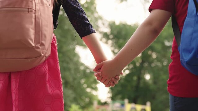 boy girl go school holding hands.students with backpacks their backs. child school friends with school bags rush lesson. hand hand close up. chidhood dream. happy schoolchildren park. kid school